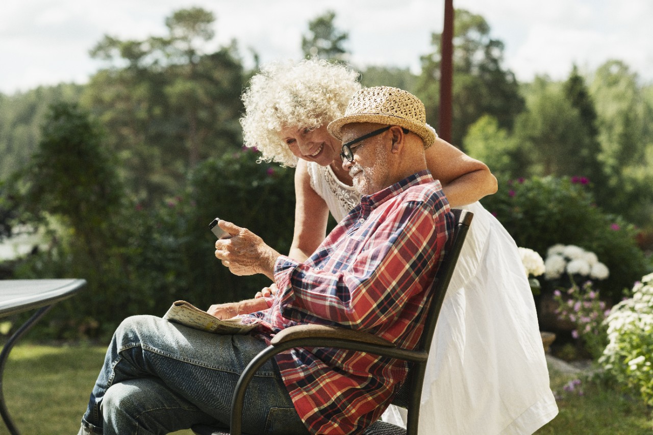 Woman and man looking at mobile in the garden